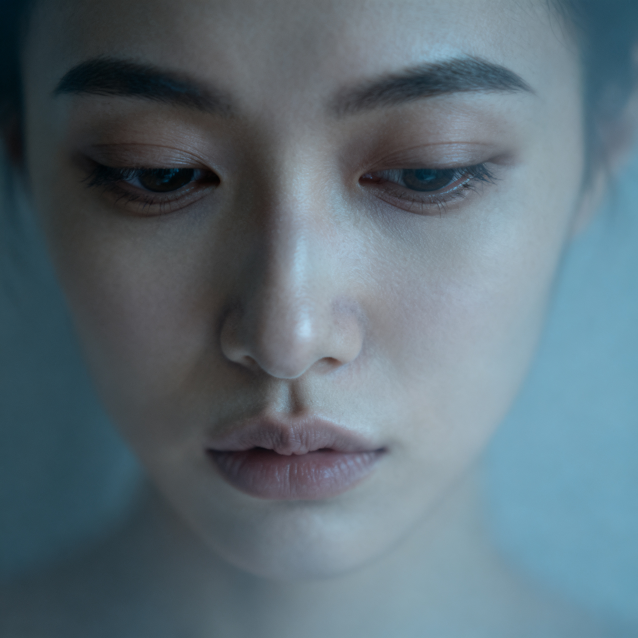A face showing quiet melancholy — downcast eyes, slightly dr