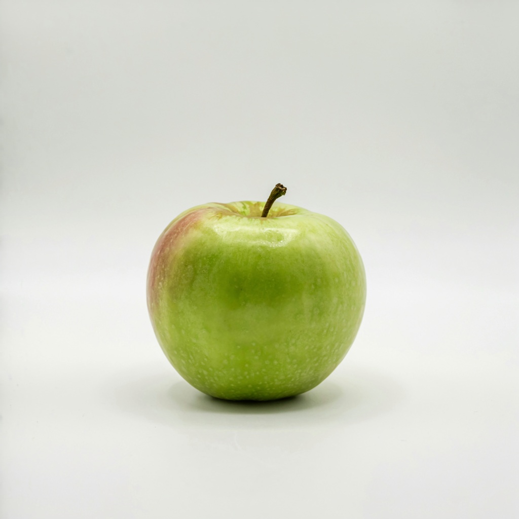 A ripe green apple on a seamless white background with soft 