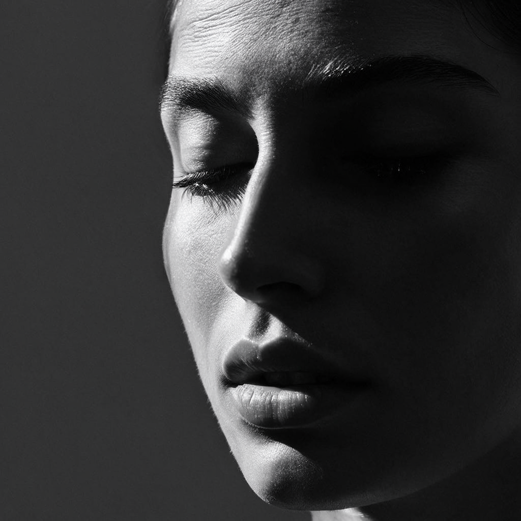 A portrait with dramatic split lighting — half the face brig