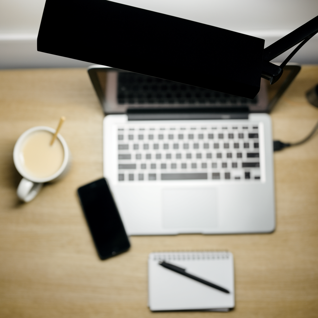 A desk scene: laptop in the center, coffee mug to the left, 