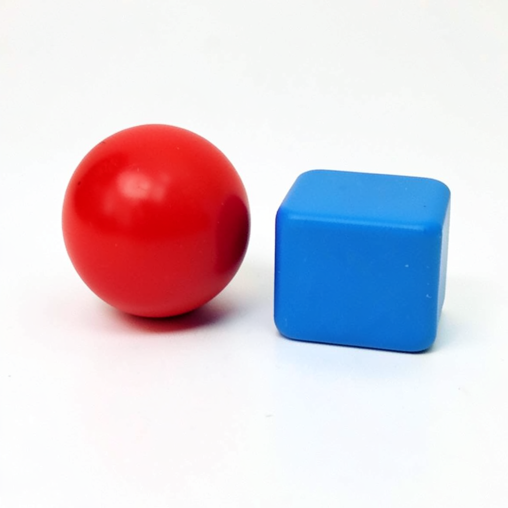 A red ball and a blue cube sitting side by side on a white s