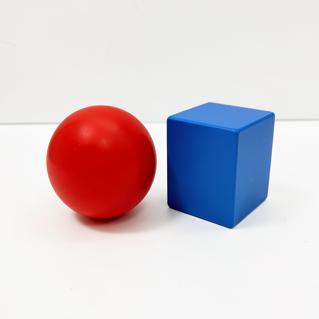 A red ball and a blue cube sitting side by side on a white s