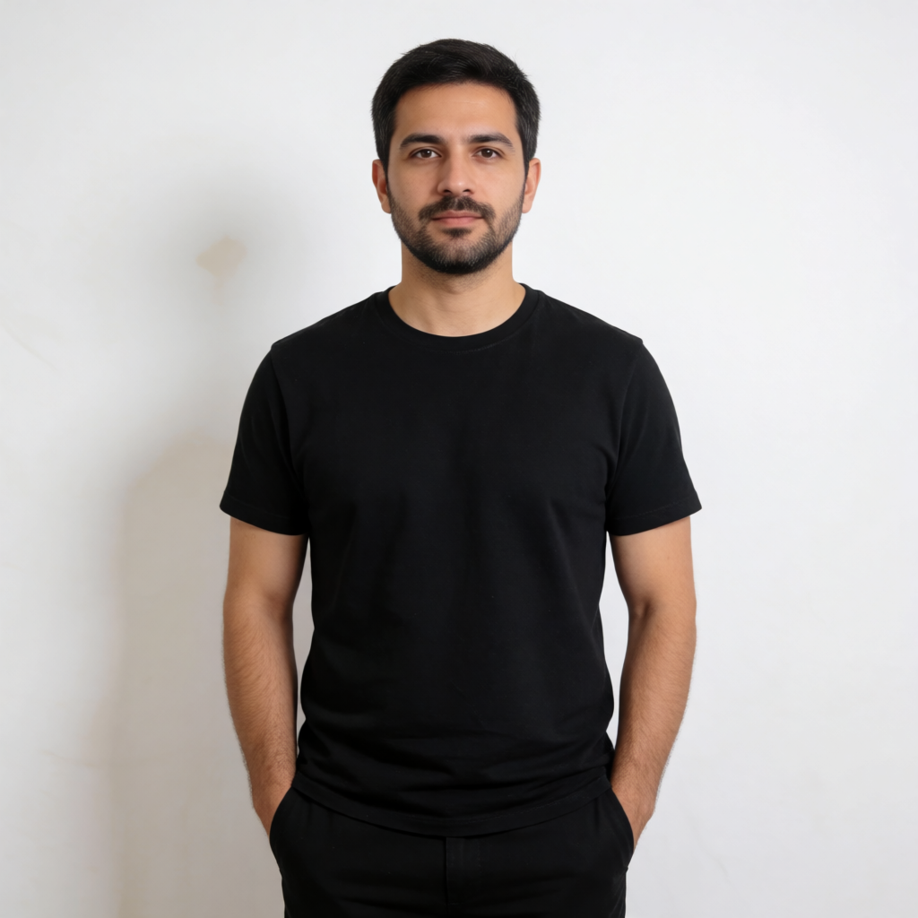 A man standing straight facing the camera, hands in pockets,