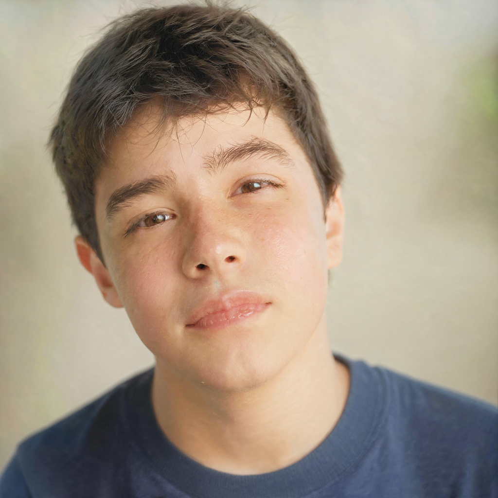 A headshot of a teenager with a relaxed, neutral face