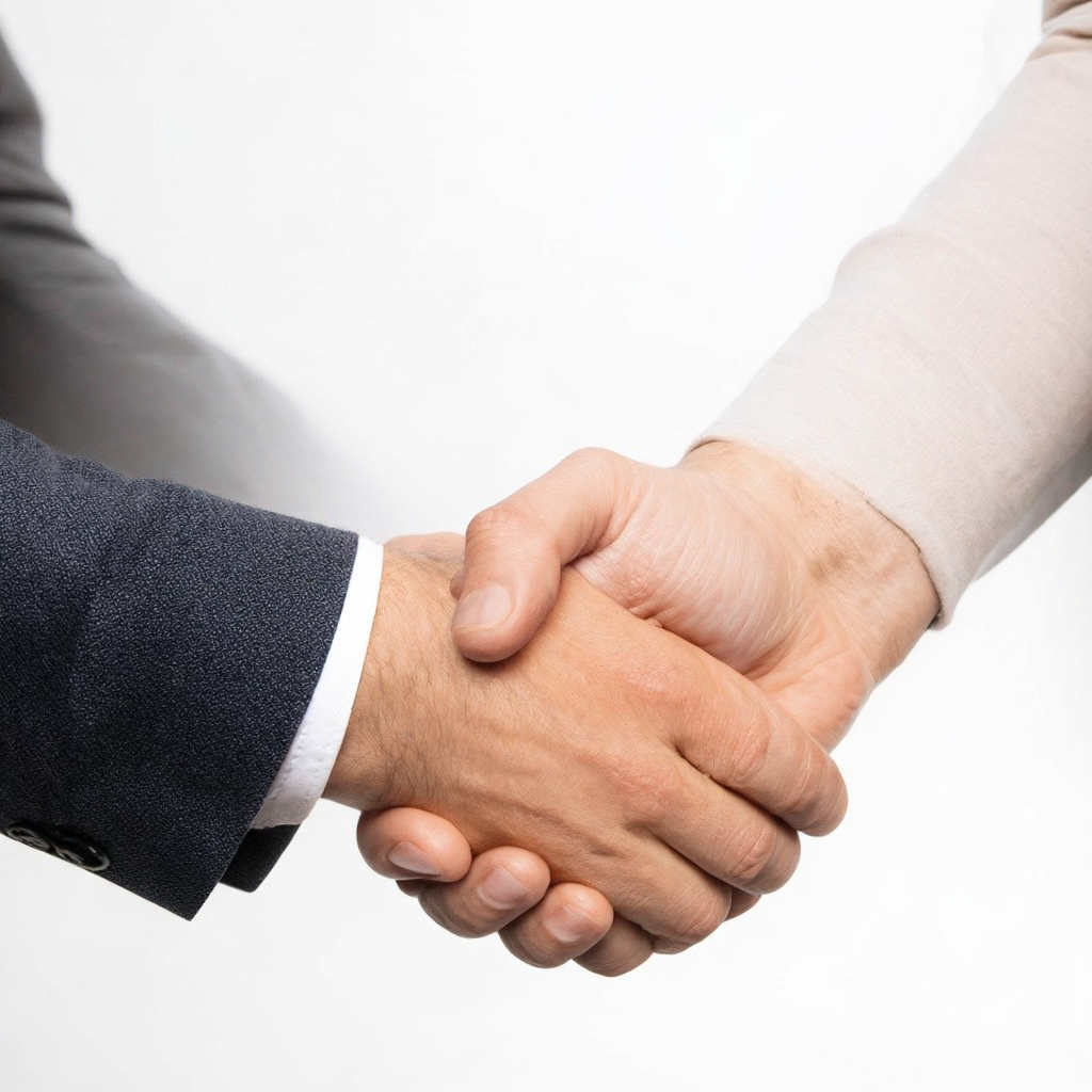 Two people shaking hands in a professional setting, all fing