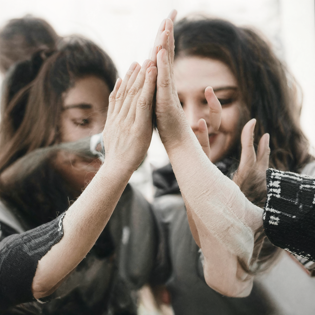 Two people doing a high-five, palms meeting with all fingers
