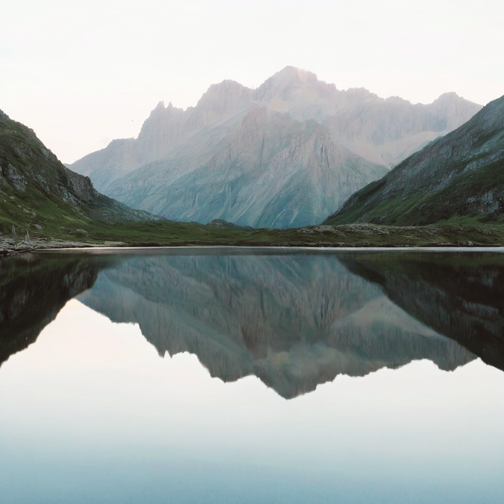 A mountain range reflected in a still alpine lake, with the 