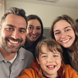 A family photo with four people: a father beaming with pride