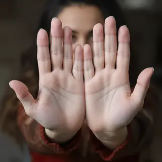 A woman holding her hands out in front of her palms-up, all 