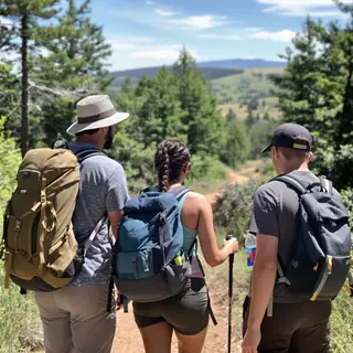 Three hikers on a trail: a man with a backpack and sunhat, a
