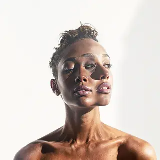 A high-key portrait of a person against a bright white backg