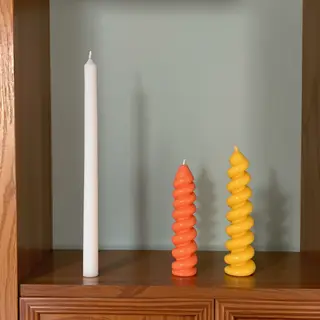 A tall thin white candle, a short fat red candle, and a medi