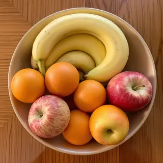 A fruit bowl containing exactly 3 bananas, 4 oranges, and 2 