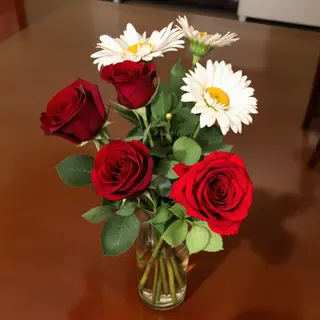 4 red roses and 2 white daisies in a glass vase on a table
