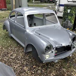 A car body with windows, doors, and headlights but no wheels