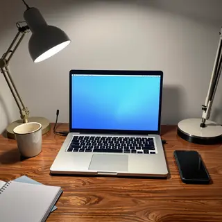 A desk scene: laptop in the center, coffee mug to the left, 