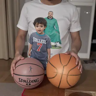 A child holding a basketball, both at correct relative sizes