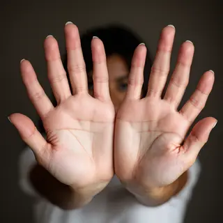 A woman holding her hands out in front of her palms-up, all 