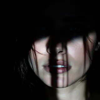 A portrait with dramatic split lighting — half the face brig