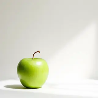 A ripe green apple on a seamless white background with soft 