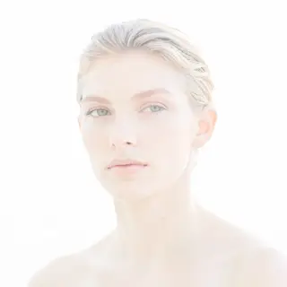 A high-key portrait of a person against a bright white backg