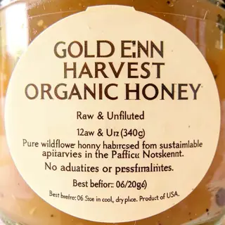 A product label for 'GOLDEN HARVEST ORGANIC HONEY' with subt