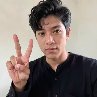 A person making a peace sign with their right hand, clearly 