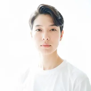 A high-key portrait of a person against a bright white backg