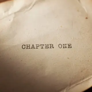 The word 'CHAPTER ONE' typed on aged paper with a vintage ty