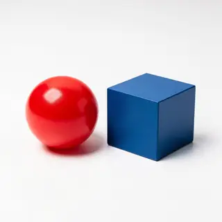A red ball and a blue cube sitting side by side on a white s