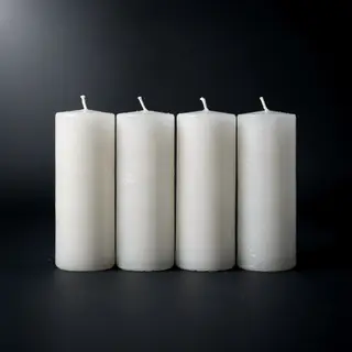 Exactly 4 white candles standing on a dark surface