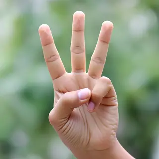 A person counting to three on their fingers, with index, mid