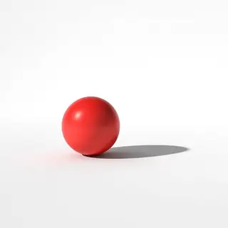 A red sphere on a white surface with a single shadow cast to
