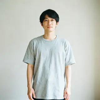 A person standing with both hands visible at their sides, fi