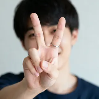 A person making a peace sign with their right hand, clearly 