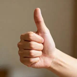 A hand giving a thumbs-up with four fingers curled and thumb