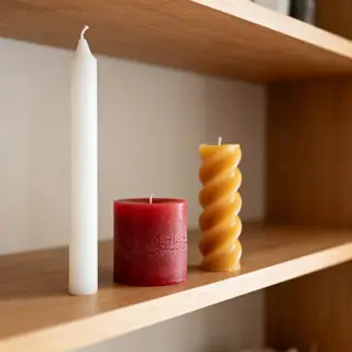 A tall thin white candle, a short fat red candle, and a medi