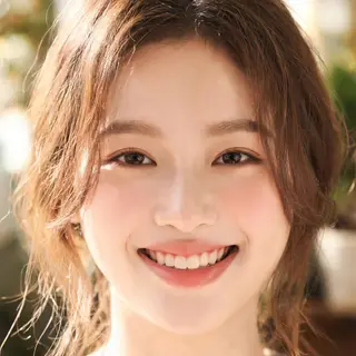 A close-up portrait of a young woman with a warm natural smi