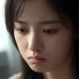 A face showing quiet melancholy — downcast eyes, slightly dr