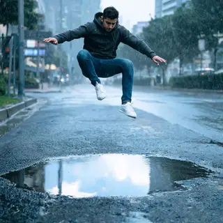 A man captured mid-jump over a puddle, body in the air with 