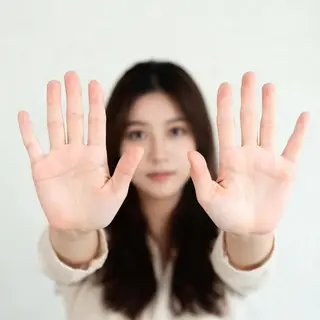 A woman holding her hands out in front of her palms-up, all 