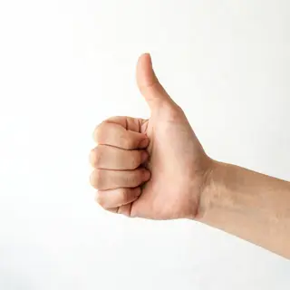 A hand giving a thumbs-up with four fingers curled and thumb