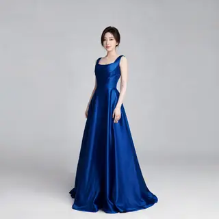 A woman wearing a royal blue evening dress against a neutral