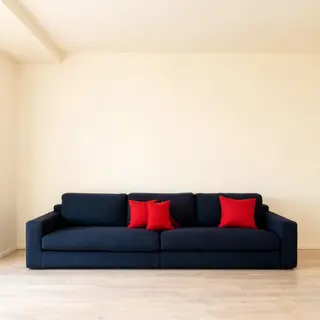 A minimalist room with walls in #F5E6CC (warm cream), a sofa