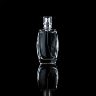 A clear glass perfume bottle on a reflective black surface w