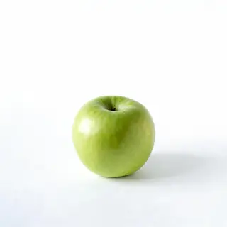A ripe green apple on a seamless white background with soft 