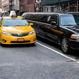 A yellow taxi and a black limousine parked next to each othe