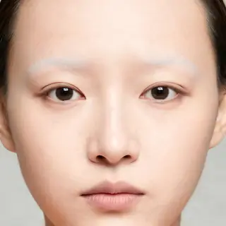 A human face with eyes, nose, and mouth but no eyebrows