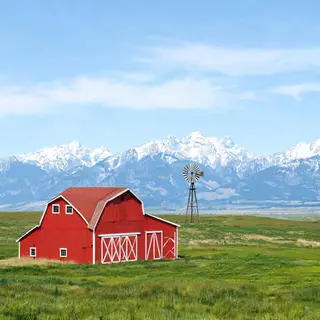 A landscape with a red barn in the foreground at large scale
