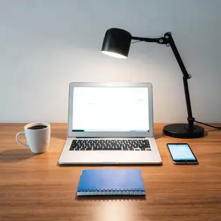 A desk scene: laptop in the center, coffee mug to the left, 